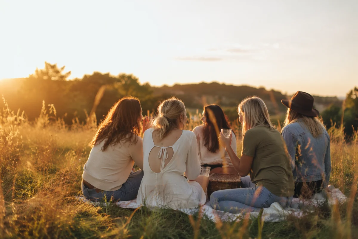 Friends Laughing Together in Golden Meadow