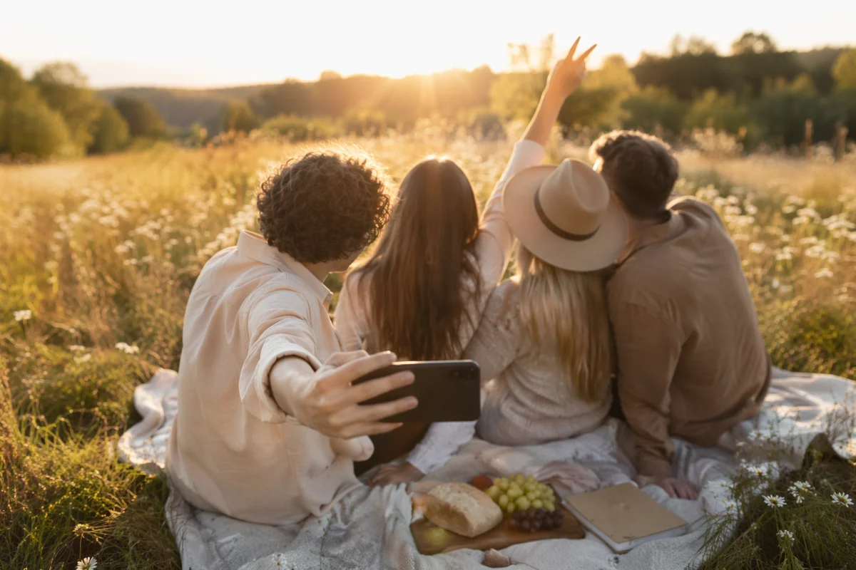 Friends Taking Sunny Meadow Picnic Selfie
