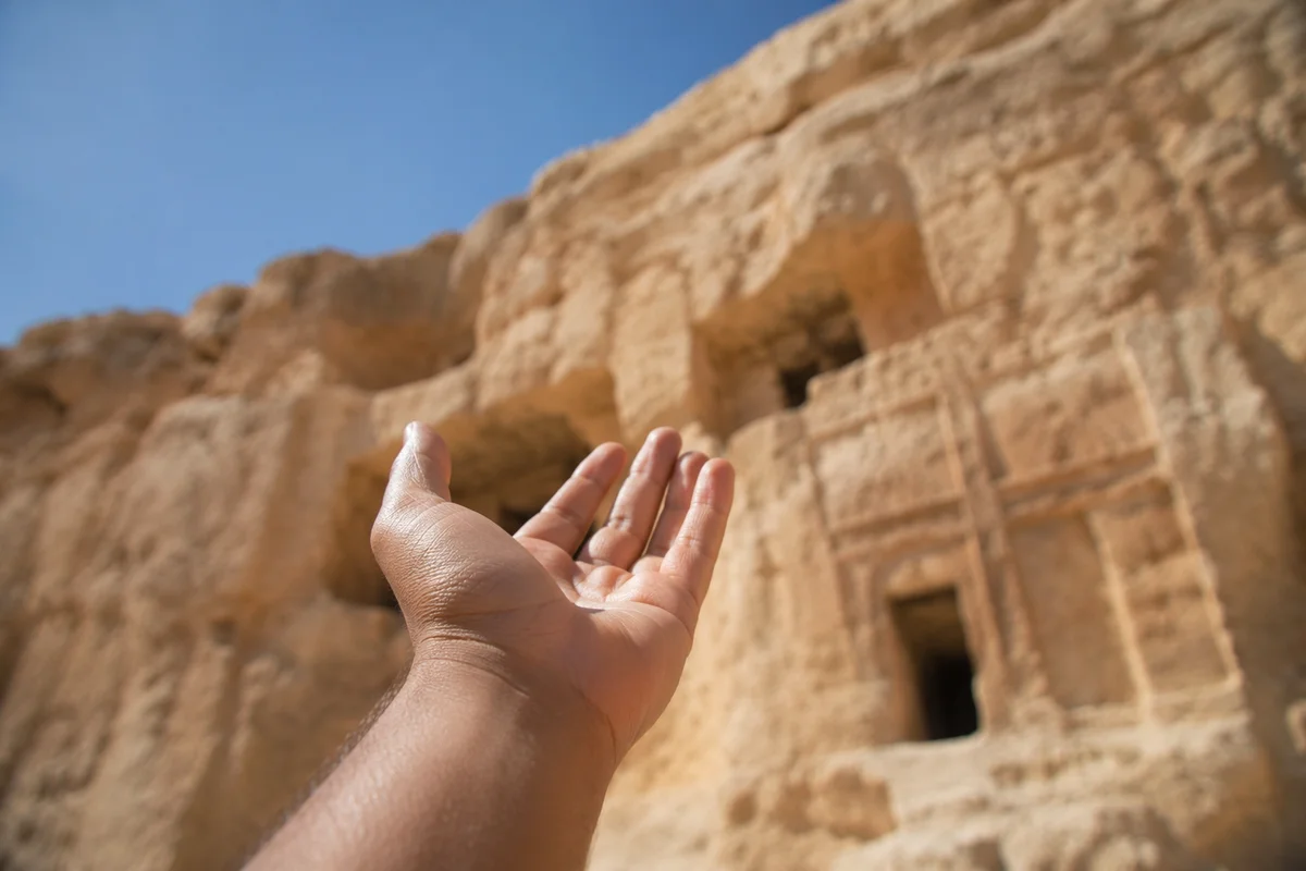 Hopeful Hand Reaching Toward Desert Sky