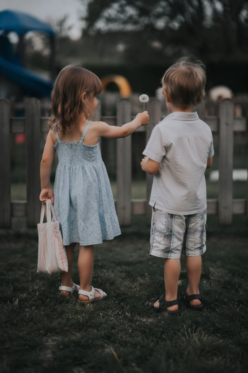 Children Sharing Dandelion on School Playground