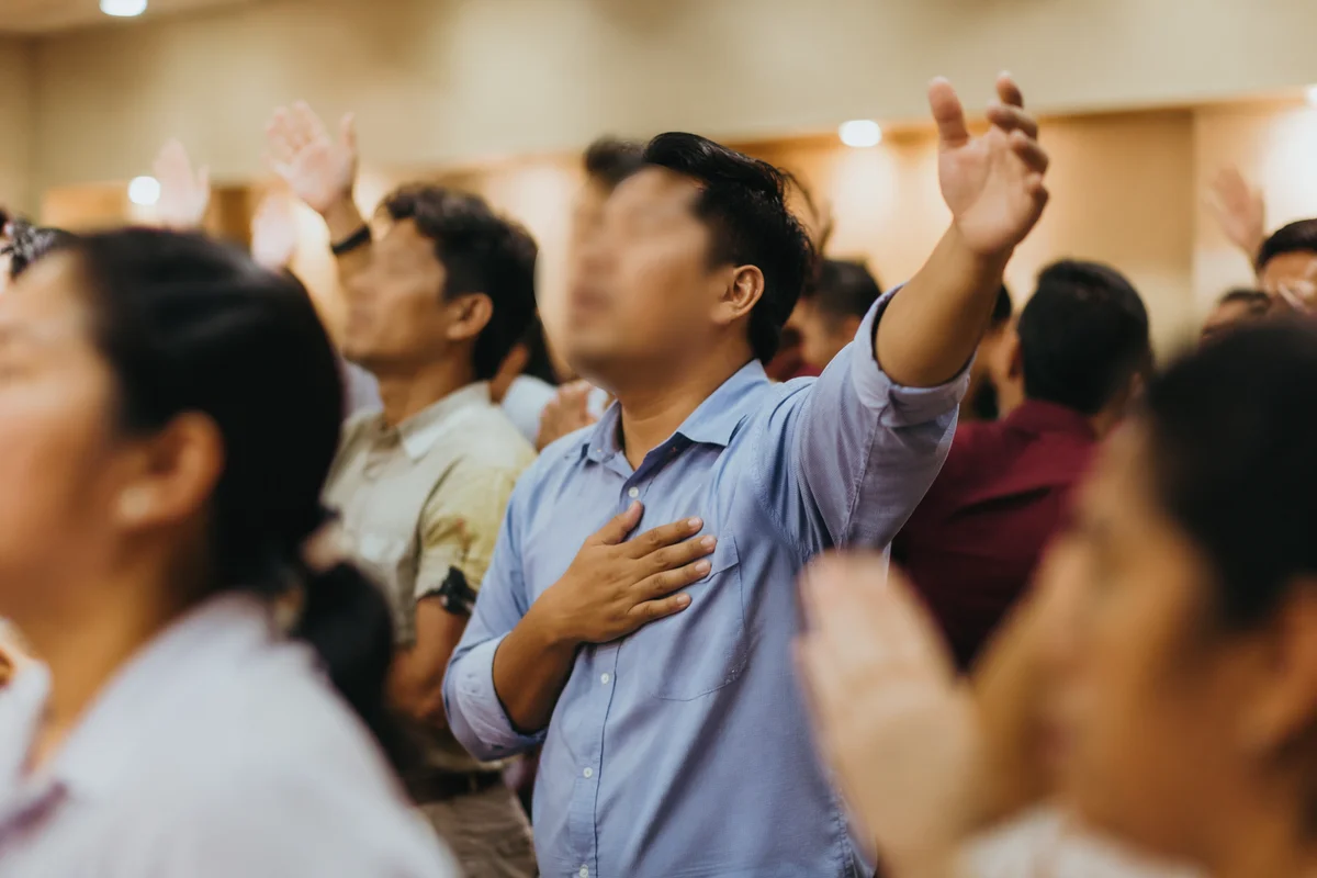 Raised Hands in Indoor Worship Gathering