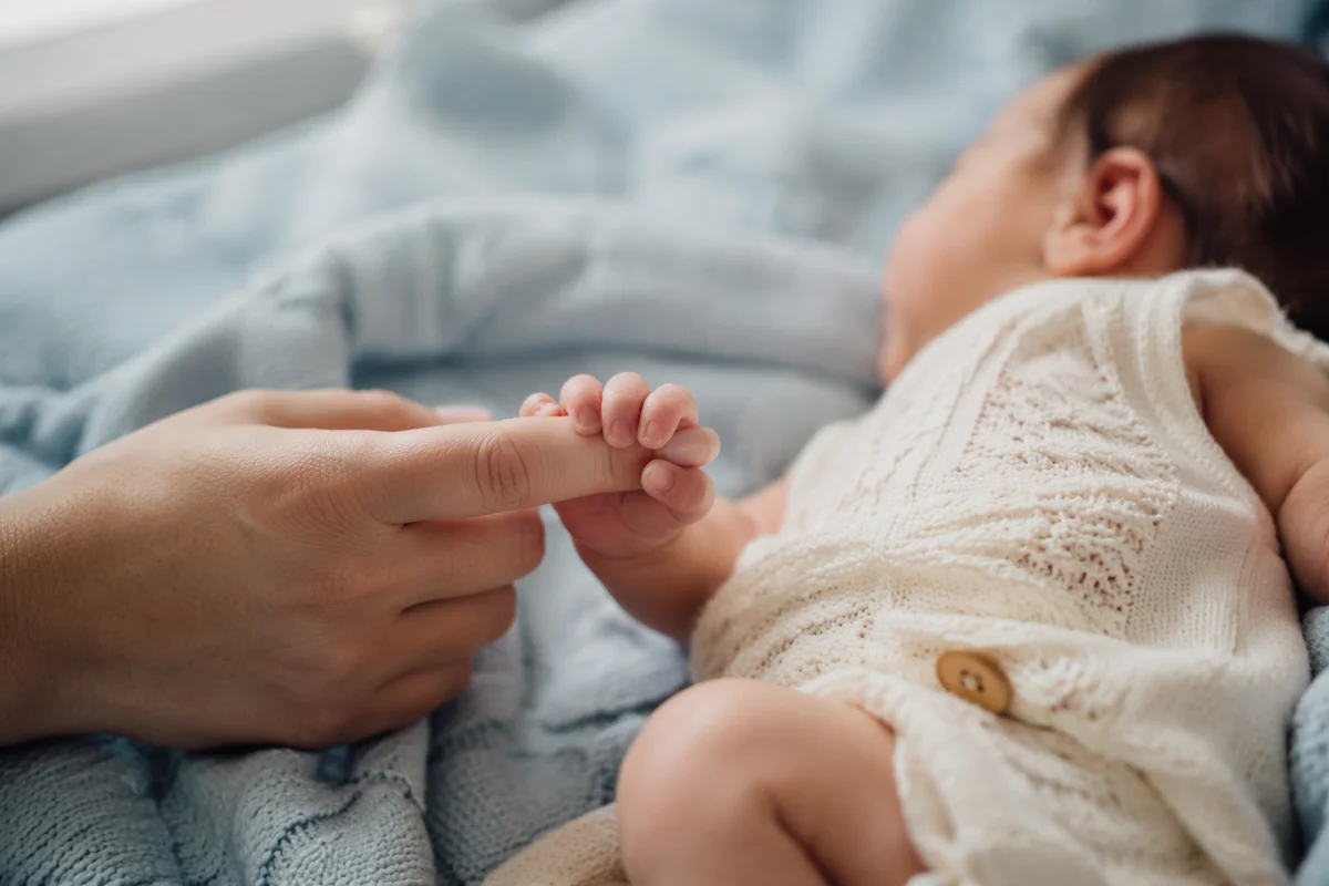 Tender Newborn Hand Holding Mother's Finger