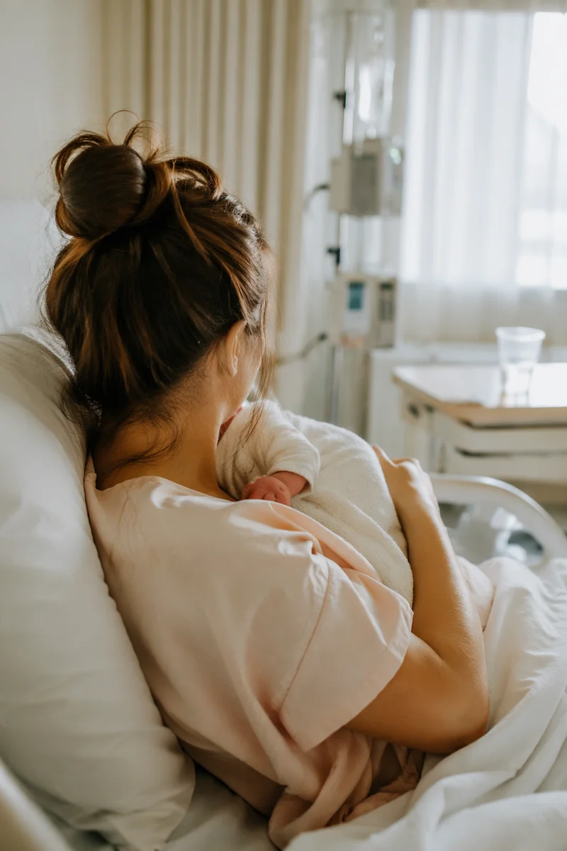Tender Mother Holding Newborn in Hospital