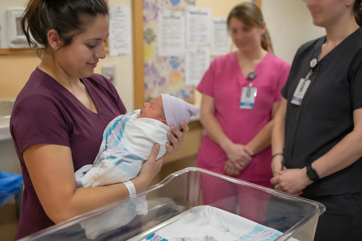 Mother Holding Newborn in Hospital Room