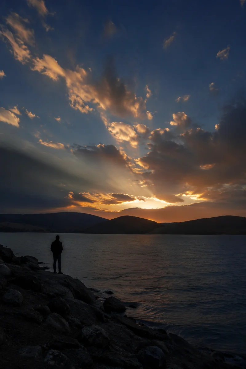 Silhouetted Prayer by Dramatic Sunset Lake