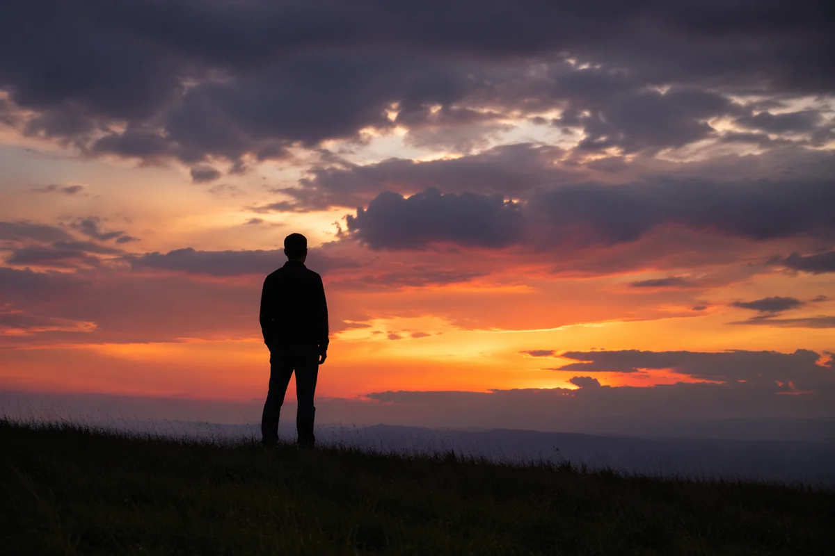 Solitary Silhouette on Grassy Ridge at Sunset