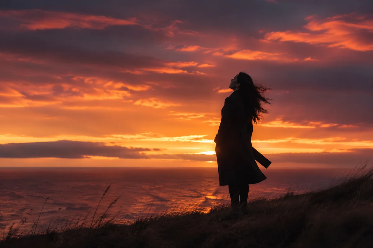 Woman Silhouette on Coastal Bluff at Sunset
