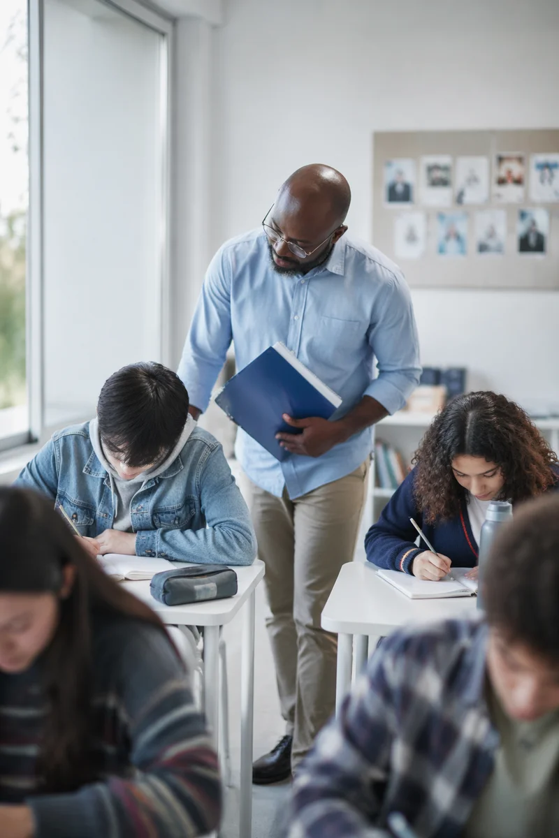 Diverse Teacher Supporting Students in Classroom
