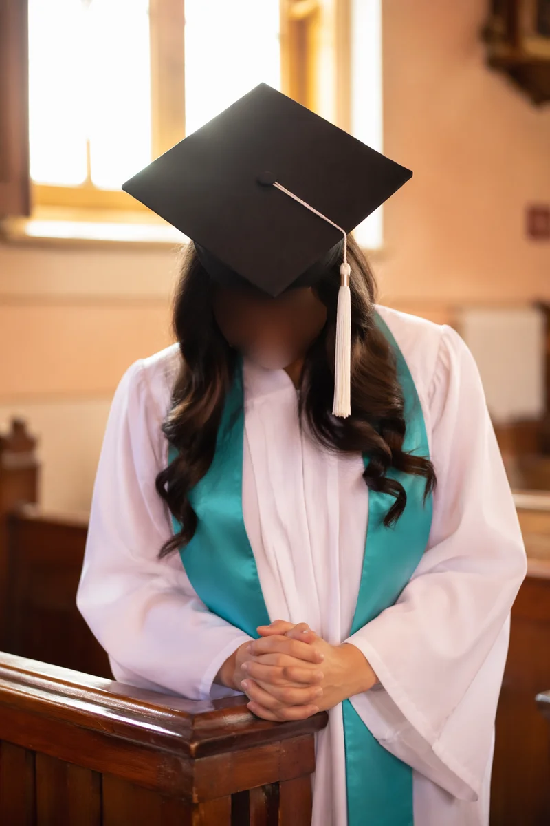 Graduate Prayer in Sunlit Chapel Portrait