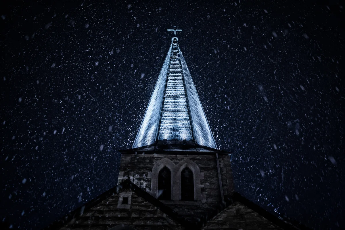 Snow Falling on Church Steeple at Night
