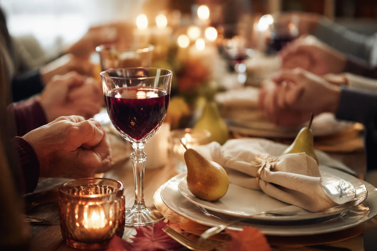 Thanksgiving Family Prayer at Candlelit Dinner Table