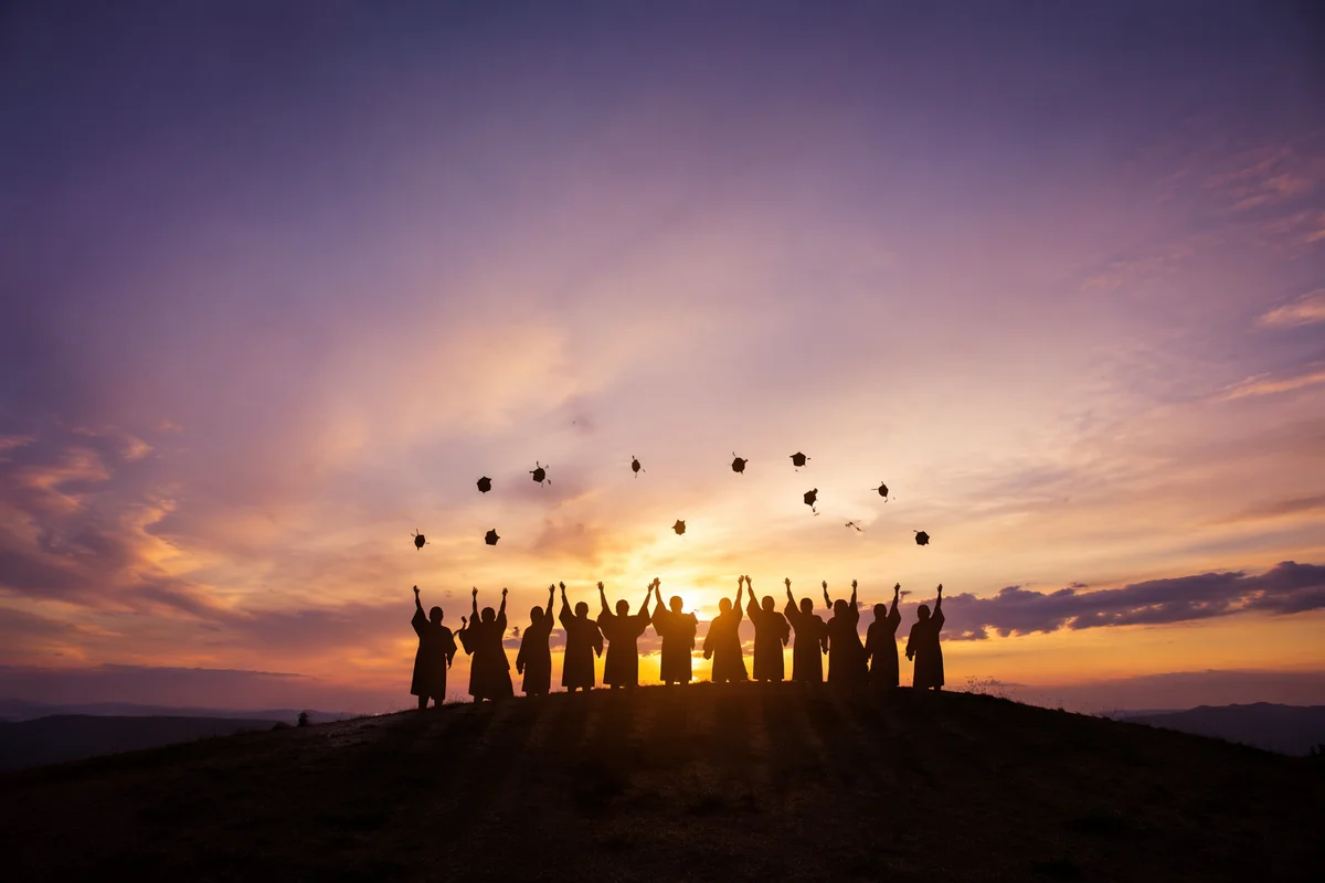 Graduates Celebrating at Sunset With Caps