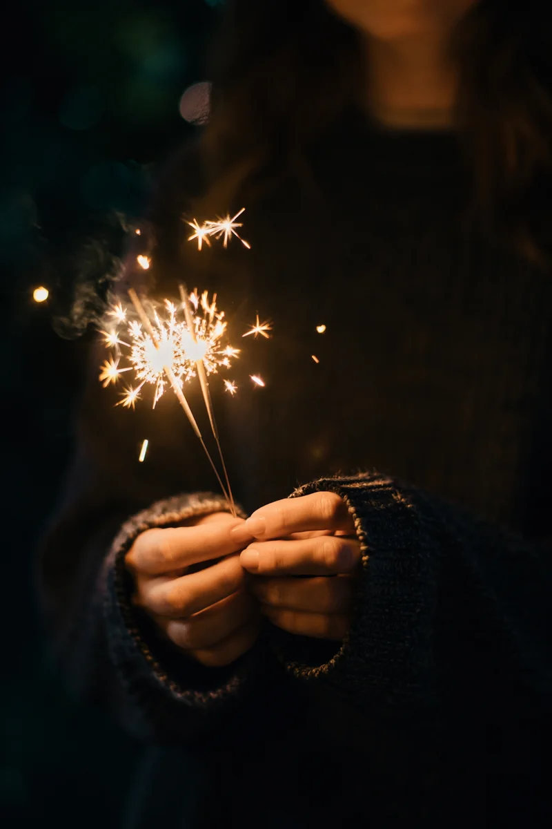 Hands Holding Sparklers at Night Celebration