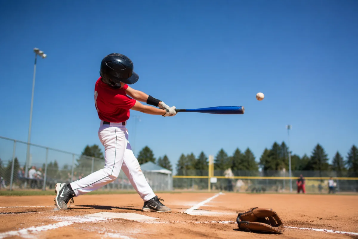 Youth Baseball Swing on Sunny Field Diamond