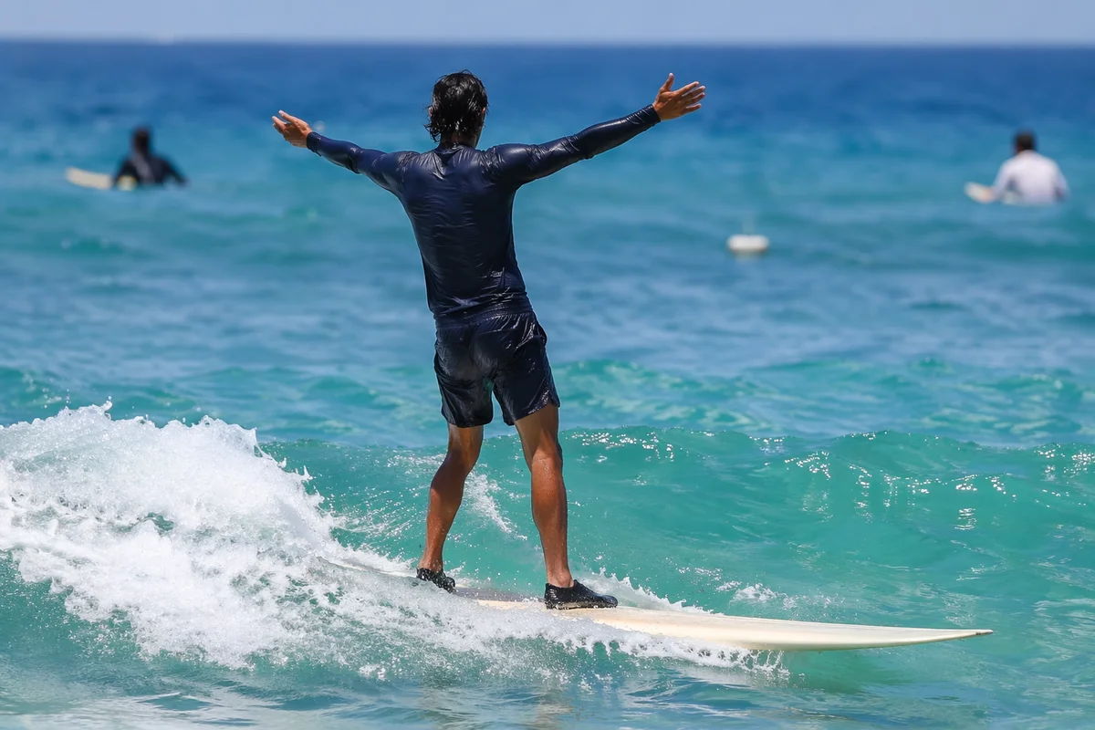 Surfer Riding Turquoise Ocean Wave
