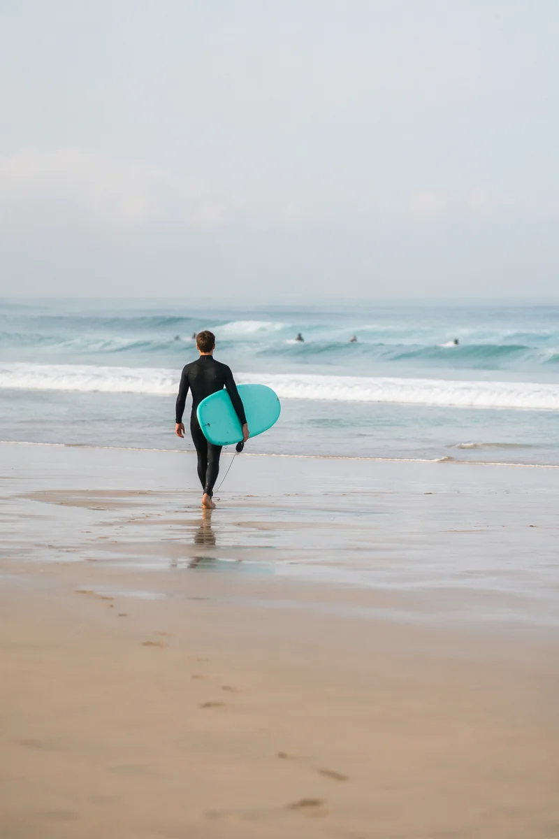 Surfer Walking Toward Gentle Summer Waves