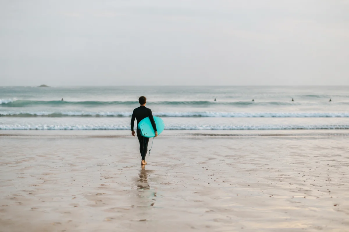 Surfer Walking Toward Gentle Summer Waves