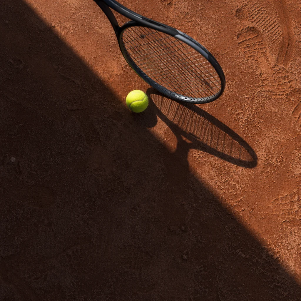 Tennis Racket and Ball on Clay Court