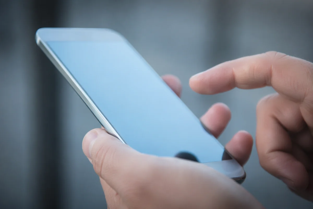 Hands Holding Smartphone With Blue Screen