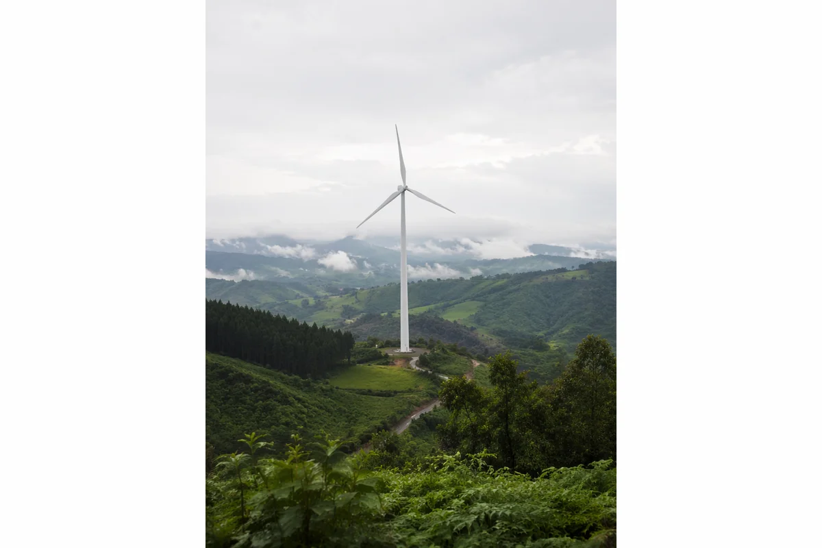White Wind Turbine Over Misty Green Hills
