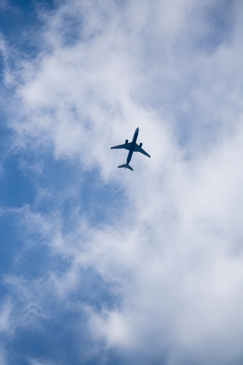Airplane Silhouette Above Blue Clouded Sky