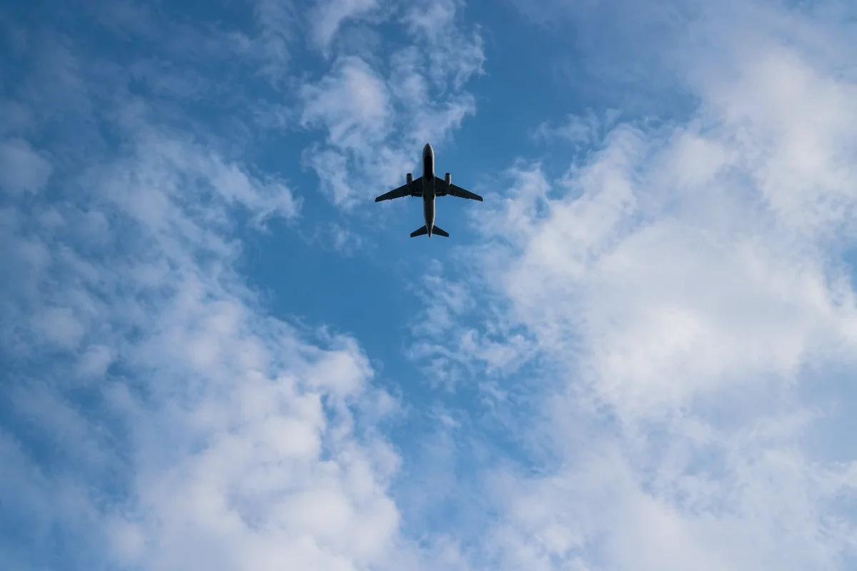 Airplane Silhouette Overhead in Blue Sky