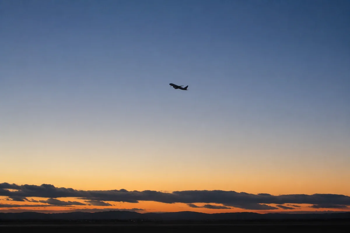 Airplane Taking Off into Blue Dawn Sky