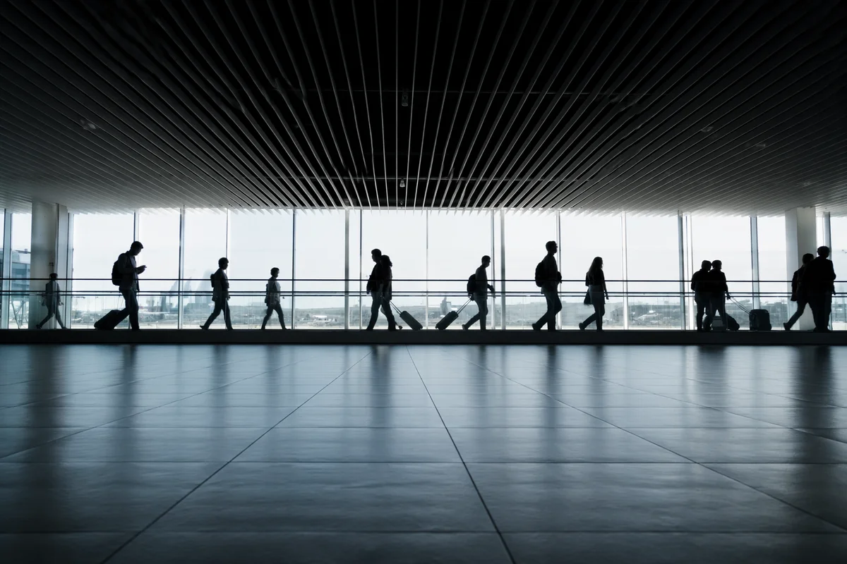 Airport Departure Concourse With Silhouetted Travelers