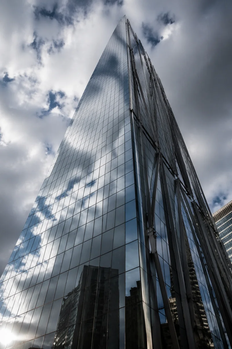 Modern Glass Skyscraper Under Cloudy Sky