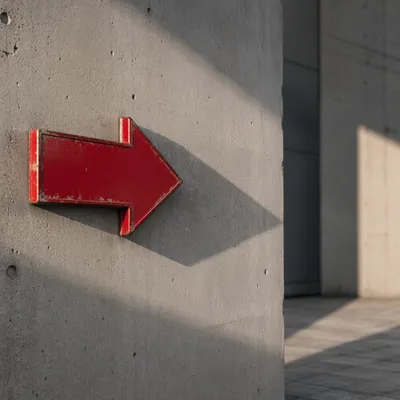 Red Arrow Sign on Concrete Wall