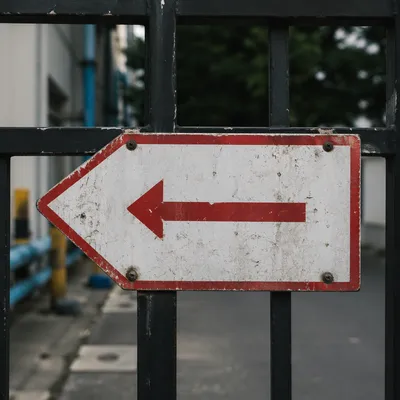 Red Arrow Direction Sign on Industrial Gate