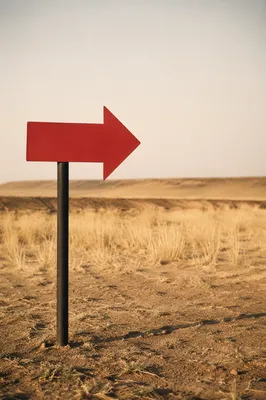 Red Arrow Sign in Minimal Desert Landscape