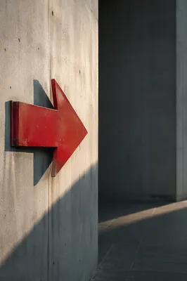Red Arrow Sign on Concrete Wall