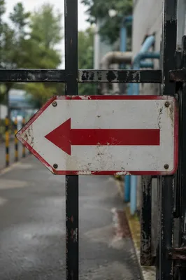 Red Arrow Direction Sign on Industrial Gate