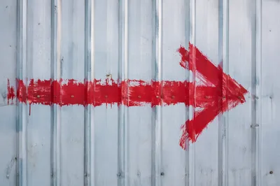 Red Arrow on Blue Gray Metal Wall