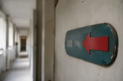 Red Arrow Direction Sign in Quiet Corridor
