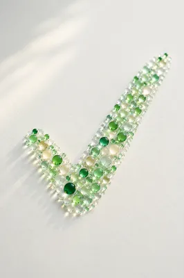 Green Dew Checkmark on White Surface