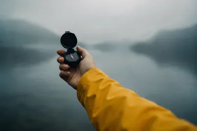 Hand Holding Compass in Misty Dawn