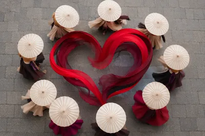 Crimson Heart Ribbons Among Elegant Parasols