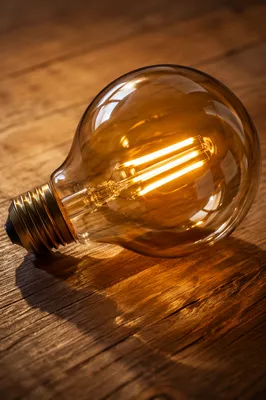Glowing Vintage Bulb on Wooden Table