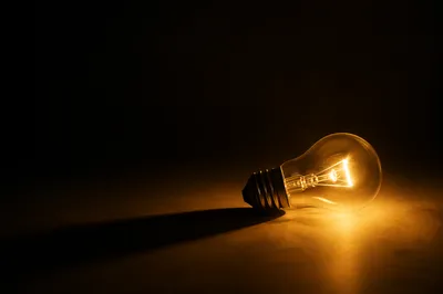 Glowing Light Bulb in Dark Minimal Scene