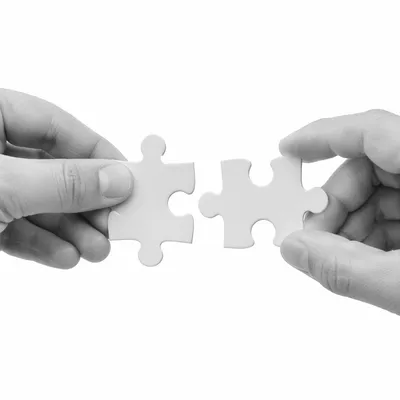 Hands Joining Puzzle Pieces in Teamwork