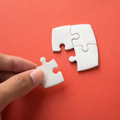 Hand Placing Puzzle Piece for Teamwork