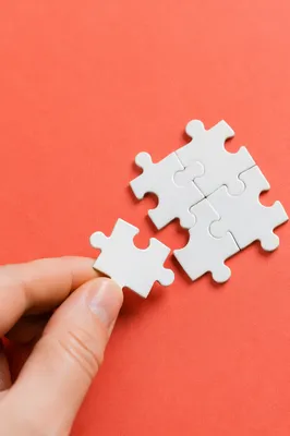 Hand Placing Puzzle Piece for Teamwork