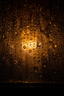 Golden Water Droplets on Dark Glass
