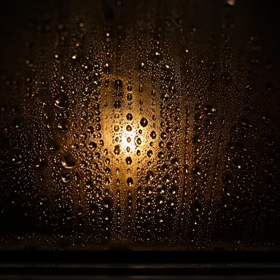 Golden Water Droplets on Dark Glass