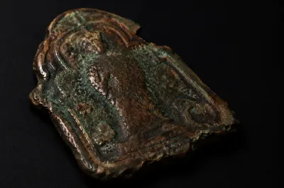 Weathered Bronze Plaque Fragment on Black