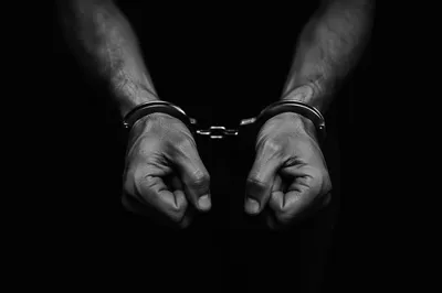 Hands in Restraints on Black Background