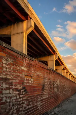 Weathered Red Brick Wall Under Overpass
