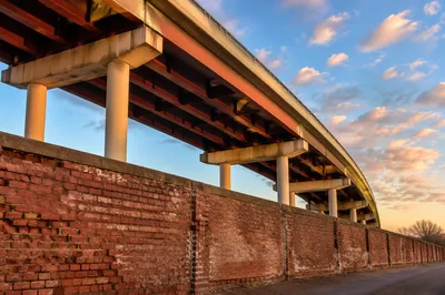 Weathered Red Brick Wall Under Urban Overpass